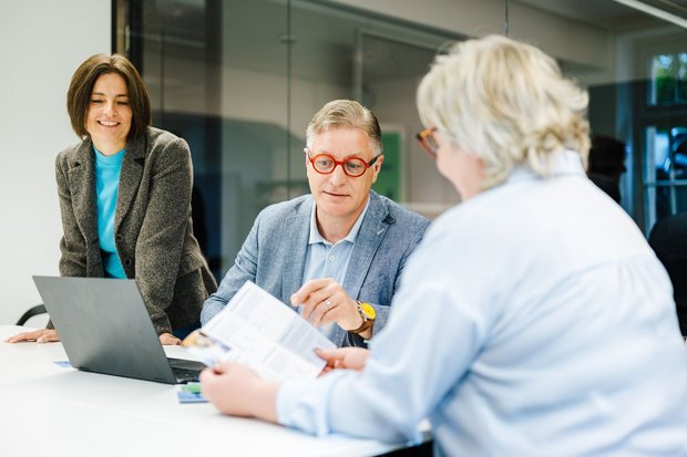 Zwei Mitarbeiter der Handwerkskammer beraten eine Kundin.