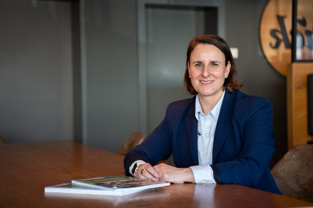 Mitarbeiter der Handwerkskammer berät einen Kunden an einem Tisch.