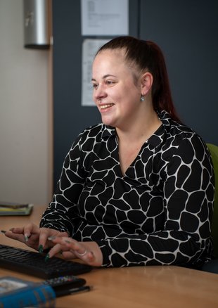 Eine Mitarbeiterin arbeitet am Computer im Büro.